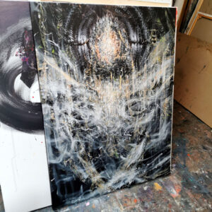 Large abstract angel painting displayed in an artist studio with luminous white textures, expressive gestural marks and dark atmospheric background.
